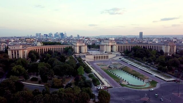 Aerial descending towards Trocad&eacute;ro, hiding behing the trees at sunrise. La D&eacute;fense in background
