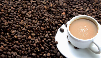A cup of coffee with coffee beans on the wood table.