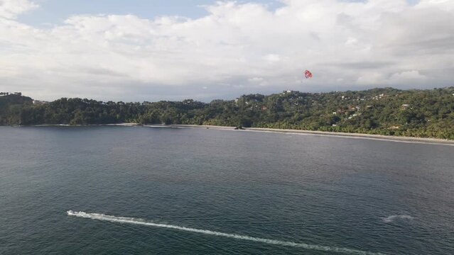 Parasailing at the tropical Manuel Antonio Beach on the stunning coastline of the Central Pacific Coast in Costa Rica. Aerial parallax