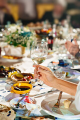 hands with glasses above the festive table
