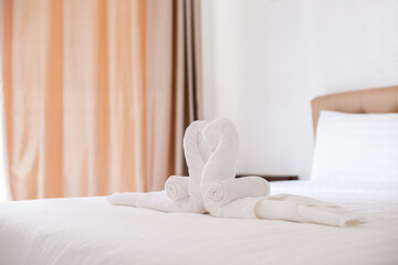 Fototapeta na wymiar A close-up of white heart-shaped towels on a hotel bed.