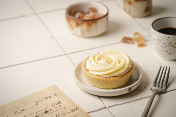 Mini tart with whipped cream and lemon, sweet dessert on white plate