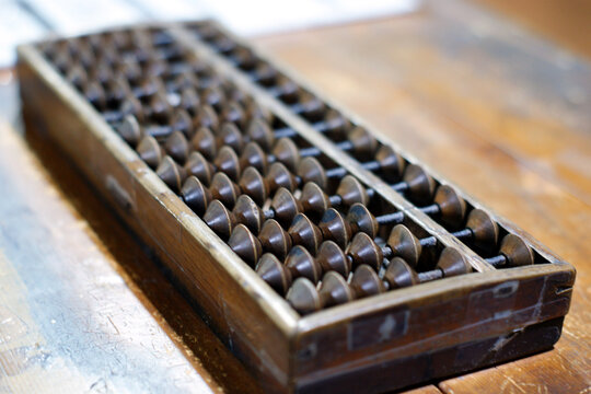 There is an abacus on the wooden table.