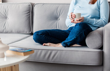 Girl sitting on the couch with a cup in her hands