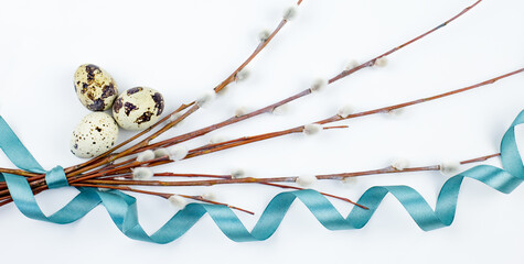 A bouquet of fluffy willow branches, Easter eggs and figures of hares on a light background. Happy Easter, Palm Sunday. Easter composition in the style of minimalism. Easter card.