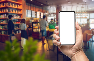 hand holding modern phone design with blank screen phone in cafe. concept ordering food and using delivery services by mobile phone or smartphone.