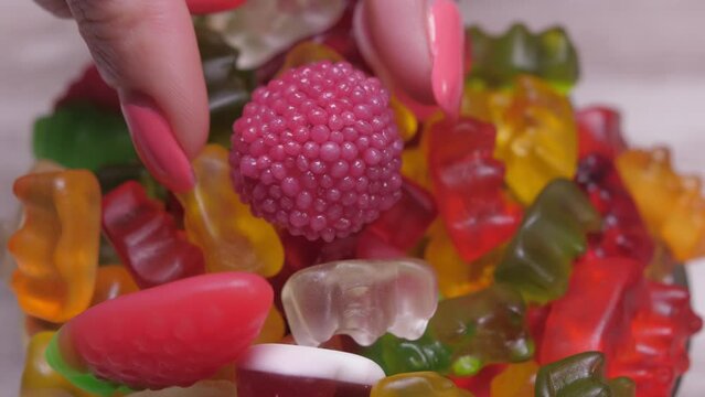 woman hand taking sweet colorful candy gummy slow motion 4k