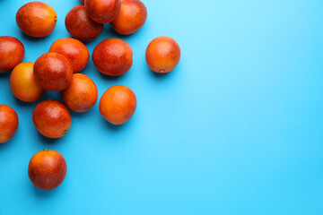 Fototapeta na wymiar Many ripe sicilian oranges on light blue background, flat lay. Space for text