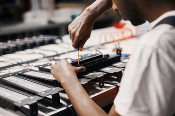 Factory worker connecting wires at circuit for LED lamps