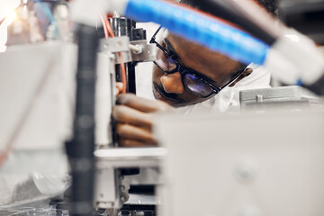 African engineer programming equipment with tablet at factory