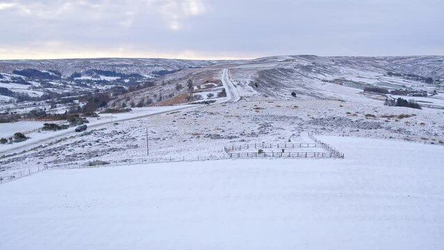 North York Moors, Castleton moors road towards hutton le hole, aerial drone footage over snowy landscape