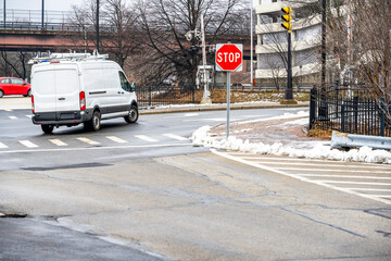 Commercial cargo mini van with roof rack turning on the city street crossroad