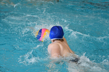 Young men play water polo in an indoor pool 