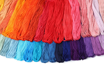 Set of colorful embroidery threads on white background, top view