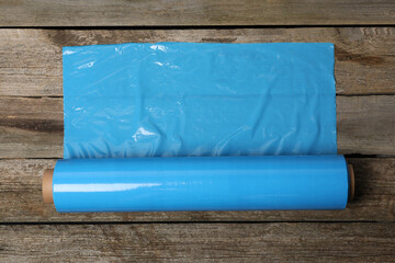 Roll of plastic stretch wrap film on wooden table, top view