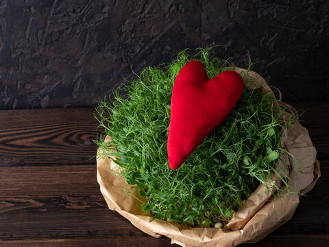 Micro-greens in a kraft bag with a red heart symbolizing health and life, an eco-friendly food
