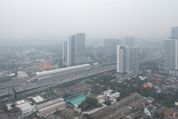 Aerial view of highway street road at Bangkok Downtown Skyline, Thailand. Financial district and business centers in urban city in Asia. Skyscraper buildings with fog. Air pollution pm2.5