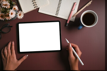 Overhead view creative woman holding stylus pen and using digital tablet on purple background.