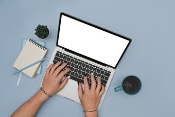 Woman hands typing on laptop computer over blue background.
