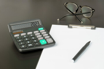 business concept with notepad calculator and glasses
