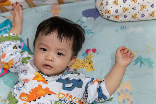 Portrait image of cute Asian Chinese 1 years old Asian Chinese baby boy on bed