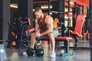 Athletic bearded man trains in the gym with kettlebells. The concept of fitness and bodybuilding
