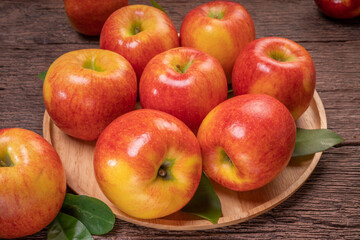 Fresh Red apple in wooden plate on wooden background, US. Red Envy apple on wooden table.