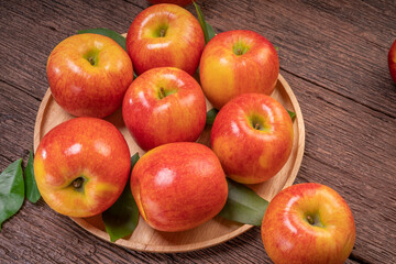 Fresh Red apple in wooden plate on wooden background, US. Red Envy apple on wooden table.