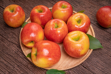 Fresh Red apple in wooden plate on wooden background, US. Red Envy apple on wooden table.