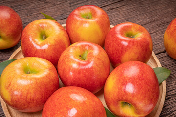Fresh Red apple in wooden plate on wooden background, US. Red Envy apple on wooden table.