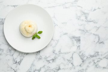 Delicious burrata cheese with basil on white marble table, top view. Space for text