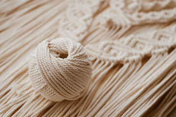 White natural cotton macrame cord in a roll on a handmade wall hanging. - obrazy, fototapety, plakaty