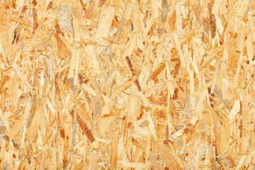 OSB, board texture and pressed sandy brown shavings background, close-up.