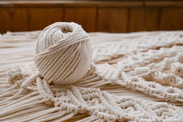 White natural cotton macrame cord in a roll on a handmade wall hanging.