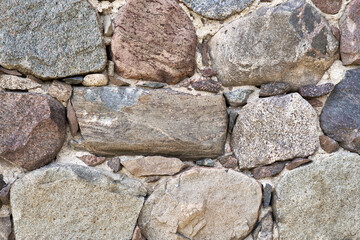 Fragment of an old stone wall. Ancient rock background