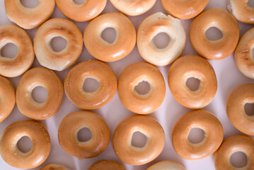 Creative pattern of bagels without sesame seeds on a light background, top view.