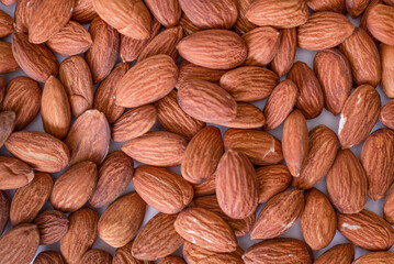 Background of big raw peeled almonds situated arbitrarily