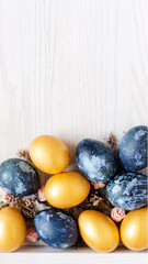 background with golden and dark blue easter eggs, screen wallpaper with easter eggs on light wooden table