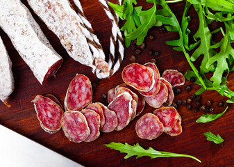 Traditional spanish thin salami sausage Fuet, sliced on cutting board