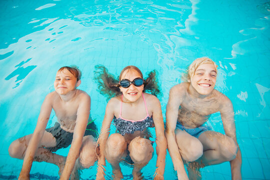Children Having Fun In Outdoor Swimming Pool