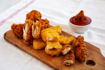Tasty Fastfood: Chicken Nuggets, Wings and Tenders with Ketchup, side view.