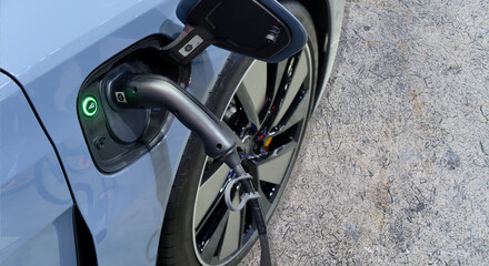 Close-up EV Car charging battery energy with plug charge from industrial electric charging machine on service station outdoor, a modern smart green energy zero emission for future, copy space
