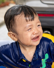 Obraz premium adorable baby boy happy and enjoying playing water on mini pool
