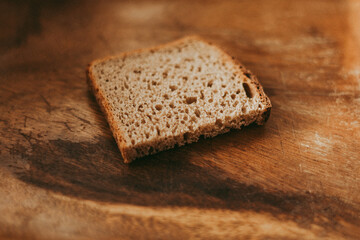 a piece of bread on a wooden background. poverty, hunger