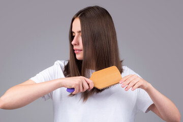 Close up portrait of happy beautiful girl with shiny hair with comb.