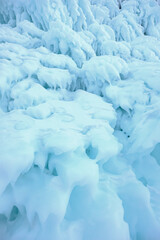 Ice and snow patterns and icicles on rocks in the cave - The rock on the frozen lake Baikal is covered with a thick layer - Baikal lake