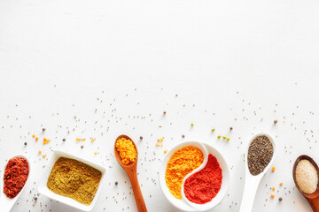 spices and seasonings in spoons and special utensils on a white background