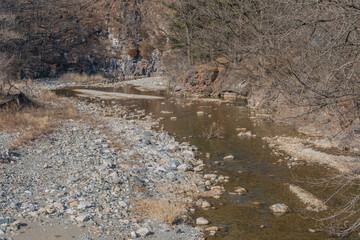 Dry rocky riverbed in woodland mountain countryside.