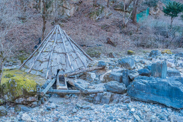 Antique watermill in dry riverbed in mountainside wilderness park.