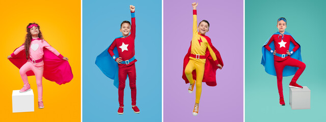 Cheerful kids in superhero costumes in studio